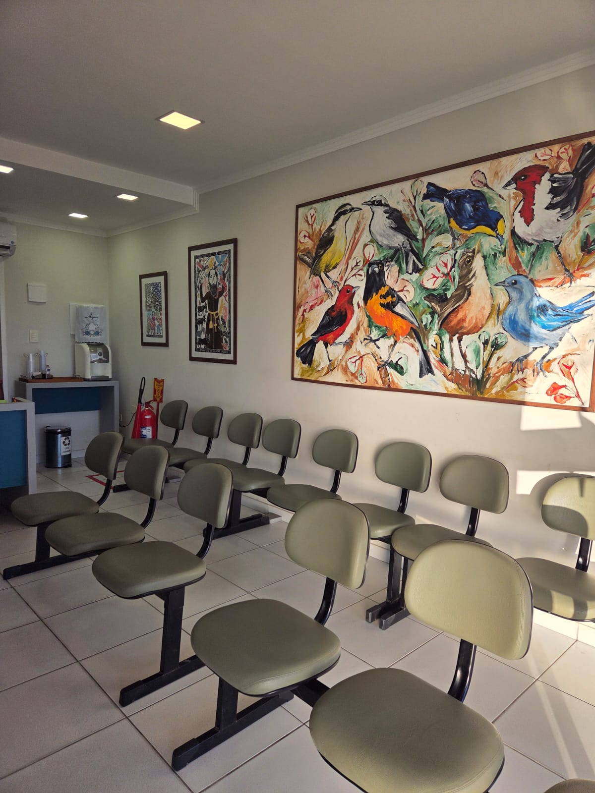 Ambiente acolhedor da sala de espera com obras de arte locais